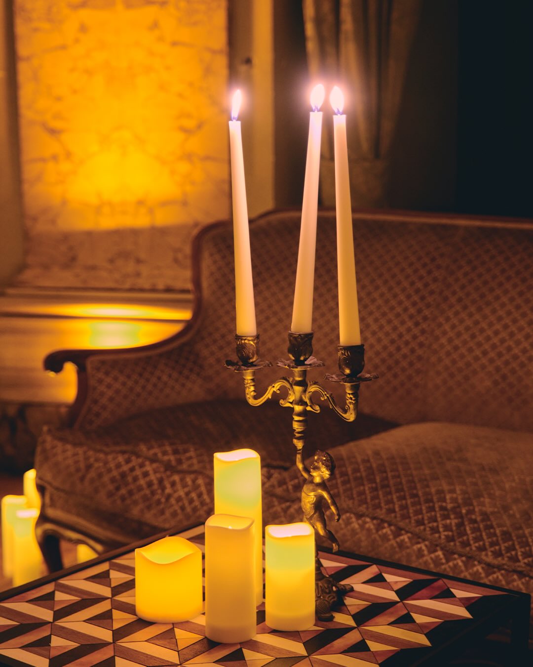 Dettaglio candlelight in una sala storica per evento moda